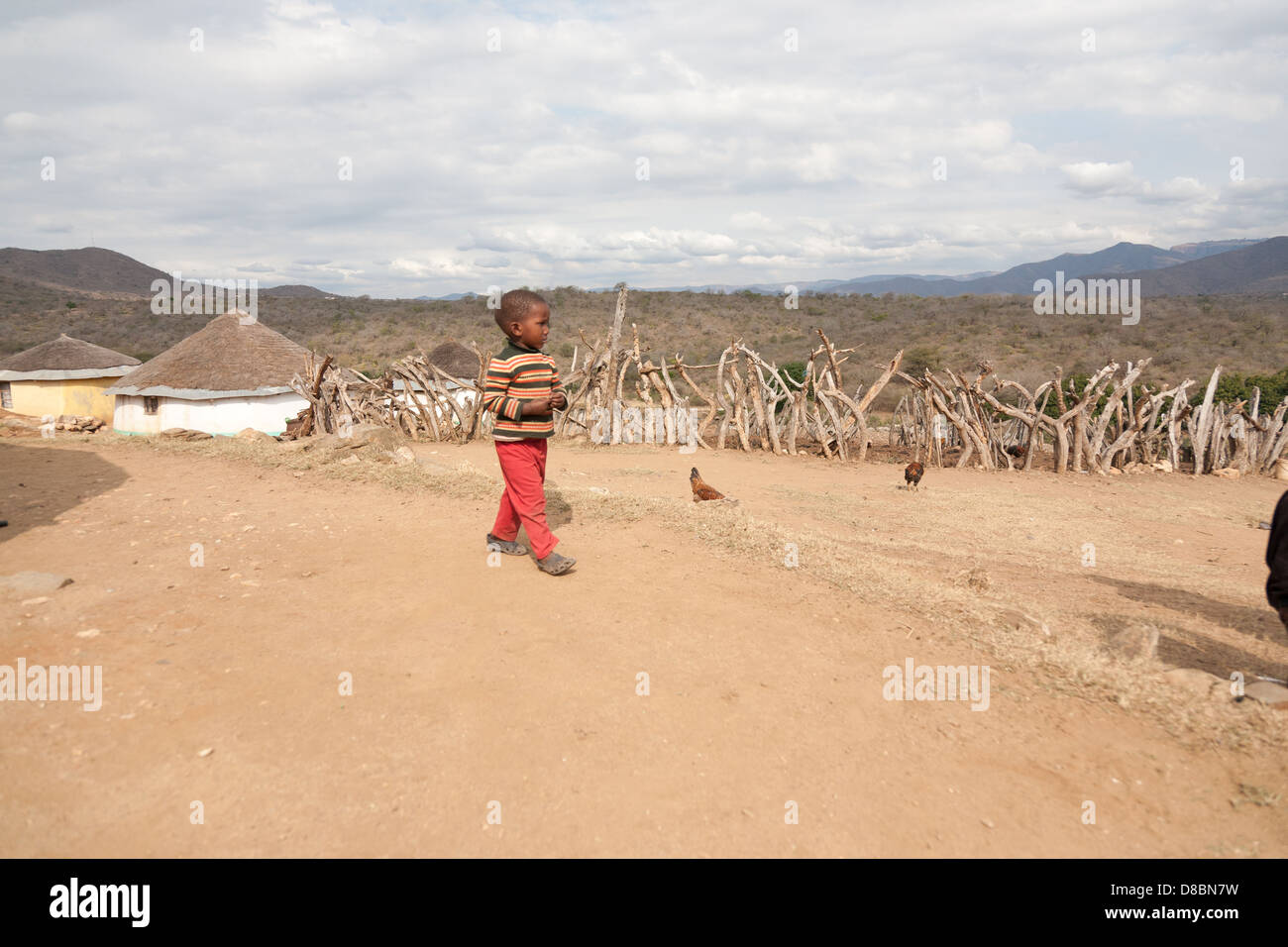 Eine afrikanische Kind zu Fuß außerhalb seiner Familie Tier Kral in eine Stockfoto
