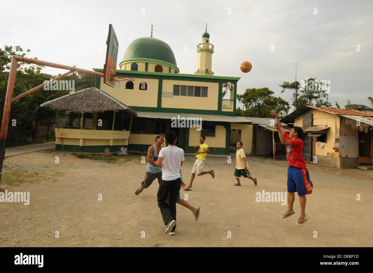 Philippinische Männer spielen Basketball auf dem Hinterhof in der Nähe einer Moschee in der Küstenstadt Puerto Galera. Insel Mindoro, Philippinen Stockfoto