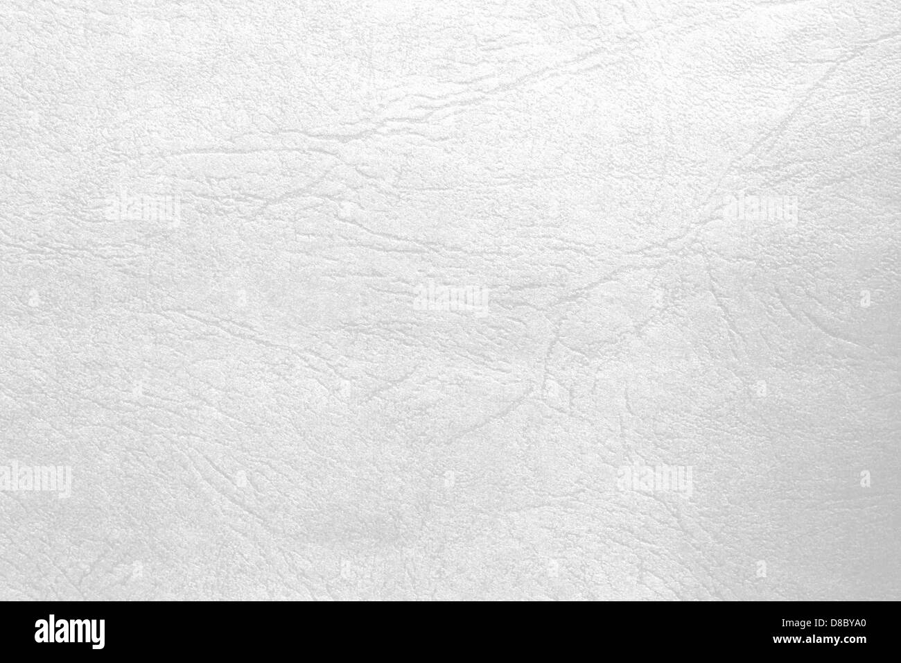 Eine Nahaufnahme von weißem Leder, das seine glatte Textur und feine Körnung hervorhebt. Das Bild fängt das raffinierte Erscheinungsbild des Leders ein und betont seine erstklassige Qualität und raffinierte Verarbeitung. Stockfoto