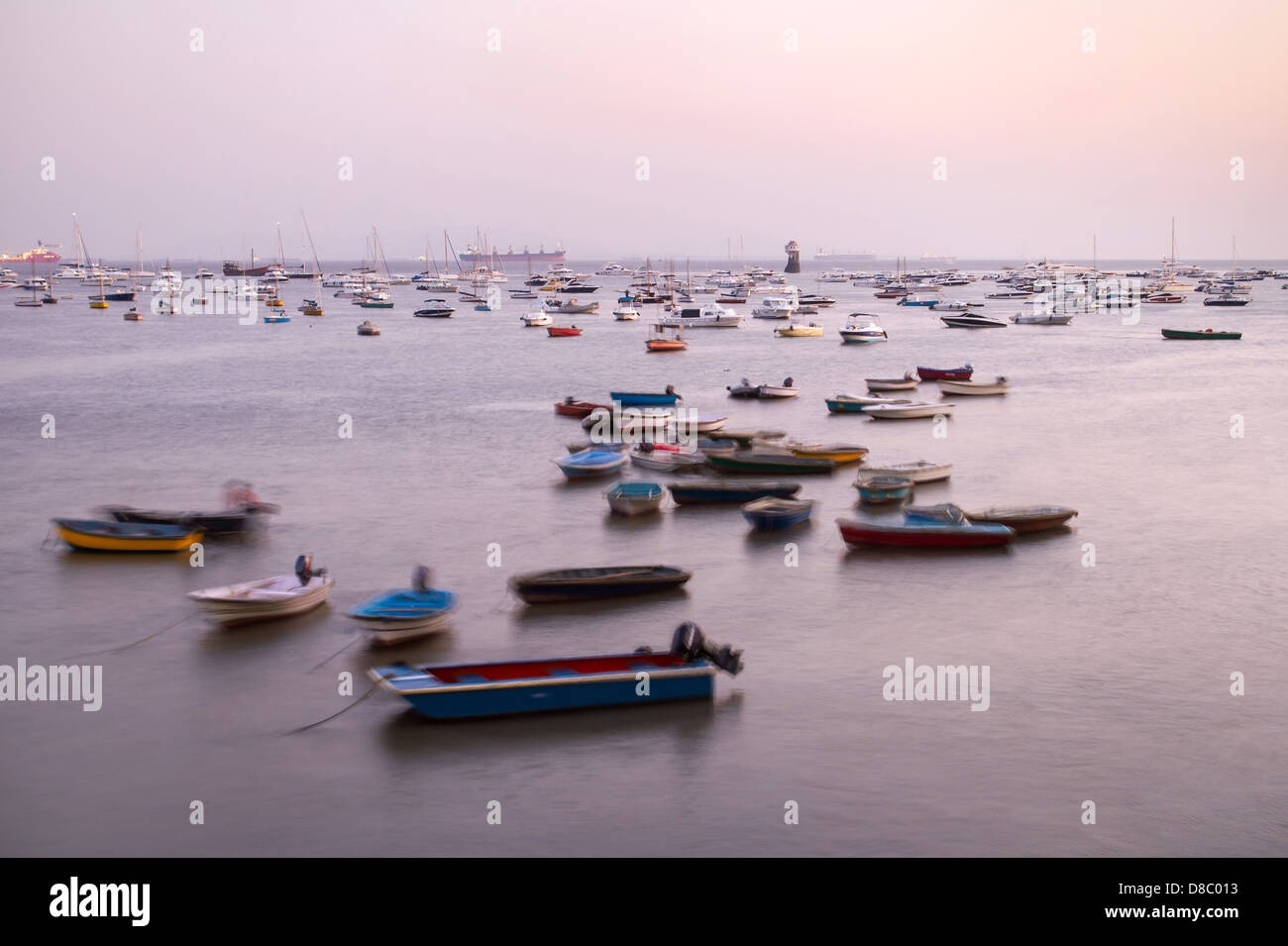 Schöne Aussicht auf viele Boote in den Wellen in der Dämmerung in Mumbai, Indien. Langzeitbelichtung geschossen. Stockfoto