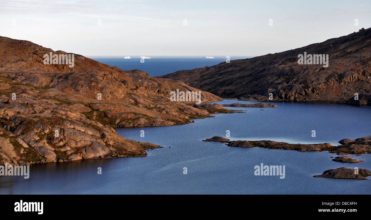 Kleine Bucht mit Eisberge schwimmen im offenen Meer im Hintergrund, in der Nähe von Kulusuk, Grönland Stockfoto