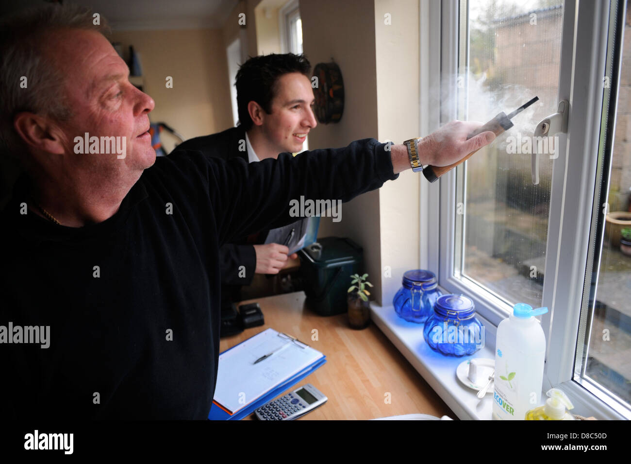 Verbesserung der Heizung Zusatzaufwand eines Hauses - Air Test Ingenieur Eddie Wainwright Tests eine Fensterdichtung für Zugluft von En beobachtet Stockfoto