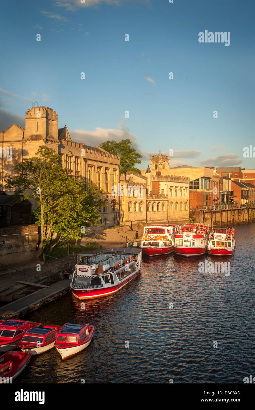River Ouse mit einer Flotte von Kreuzfahrt- und Touristenausleihbooten, die an einem sonnigen Sommerabend in York an der Guildhall festgemacht wurden. Stockfoto