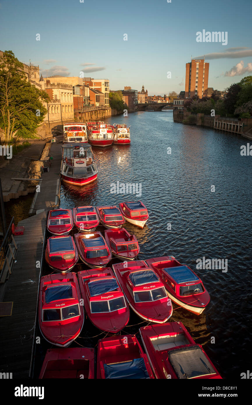 River Ouse mit einer Flotte von Kreuzfahrt- und Touristenausleihbooten, die an einem sonnigen Sommerabend in York an der Guildhall festgemacht wurden. Stockfoto