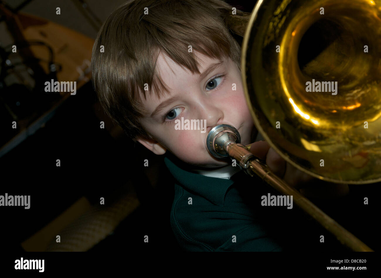 Kleiner Junge spielt die grosse Posaune Stockfoto