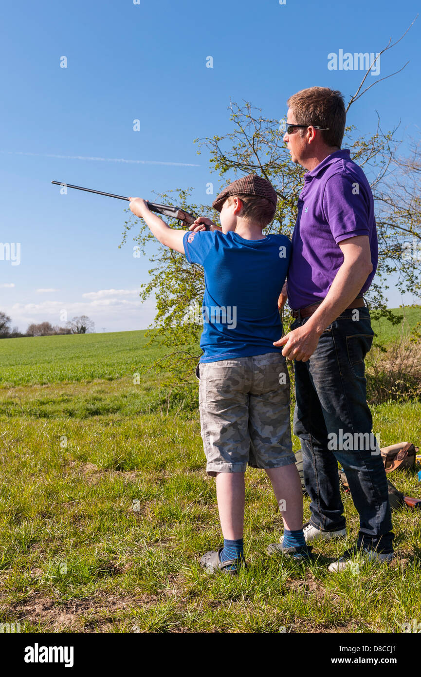 Ein 9-jähriger Junge,.410 Schrotflinte im Vereinigten Königreich zu schießen lernen Stockfoto