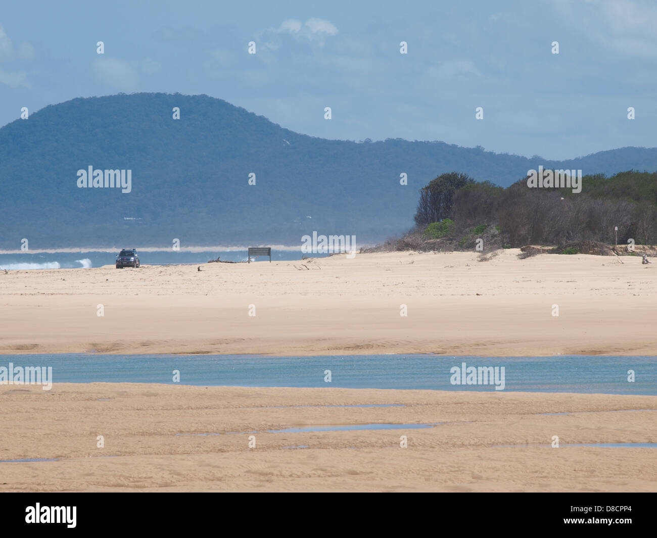ENTFERNTE AUTOS FAHREN AUF SANDSTRASSE, STRAND, NAMBUCCA KÖPFE, NEW SOUTH WALES AUSTRALIEN Stockfoto
