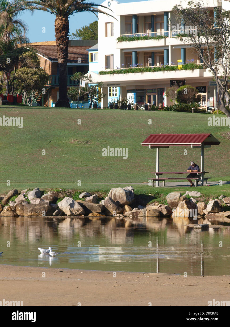 Person sitzen auf der überdachten Sitzbank bei South West rocks New South Wales Australien Stockfoto