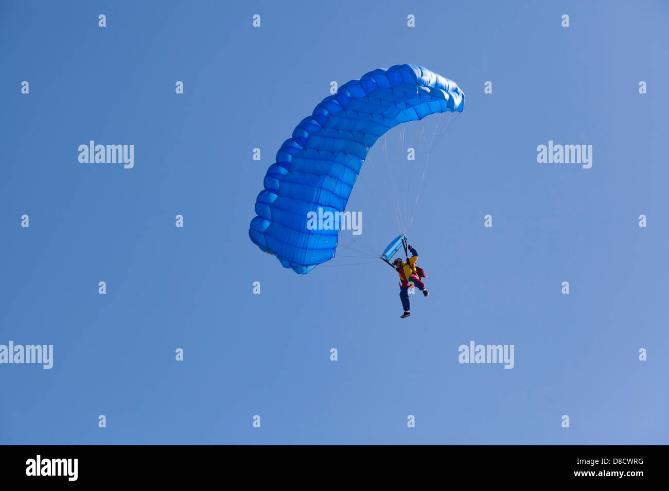 Mann mit Fallschirm fliegen auf einem klaren blauen Himmel perfekt Stockfoto
