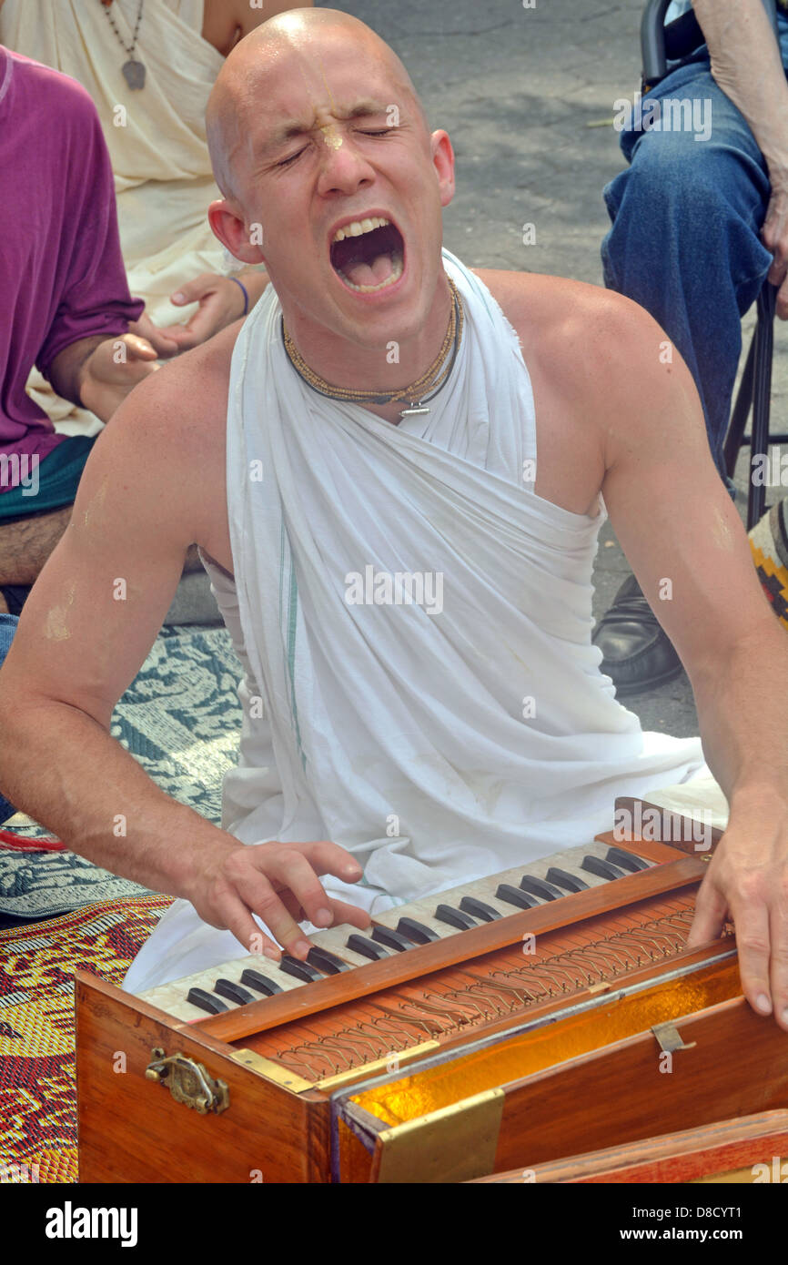 Junge kahl Hare-Krishna-Street Performer ein Orgelspiel in Union Square Park in New York City Stockfoto