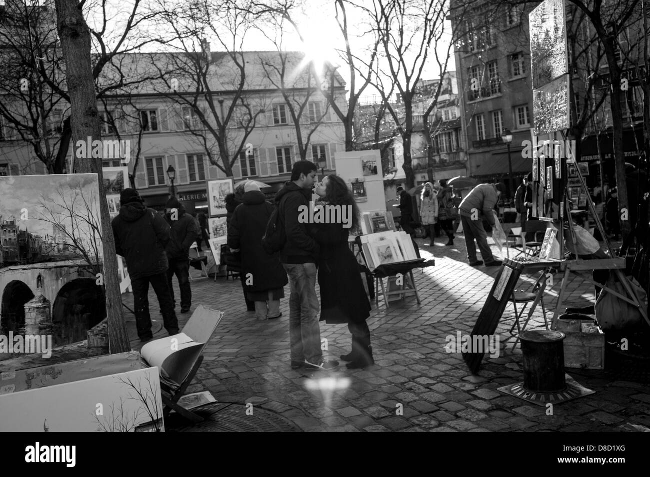 Ein verliebtes Paar teilt sich einen öffentlichen Kuss auf dem Place du Tertre-Kunstmarkt im Viertel Montmartre in Paris, Frankreich. Stockfoto
