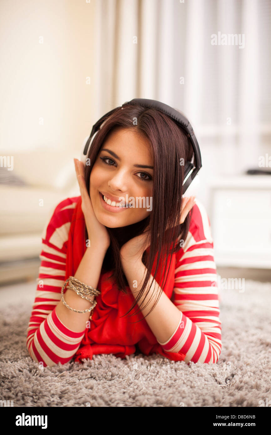 Junge schöne Frau im hellen Outfit die Musik zu Hause genießen Stockfoto