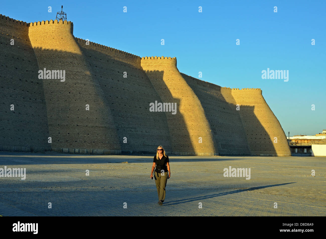 Die Mauer um die Arche in Buchara mit einem Touristen im Vordergrund Stockfoto