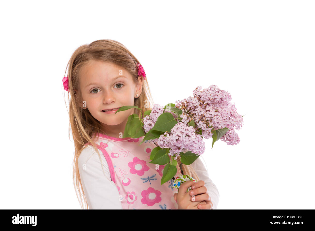 Glückliche kleine Mädchen mit langen Haaren trägt Sommerkleid und lila Blumen hält. Isoliert auf weißem Hintergrund. Stockfoto