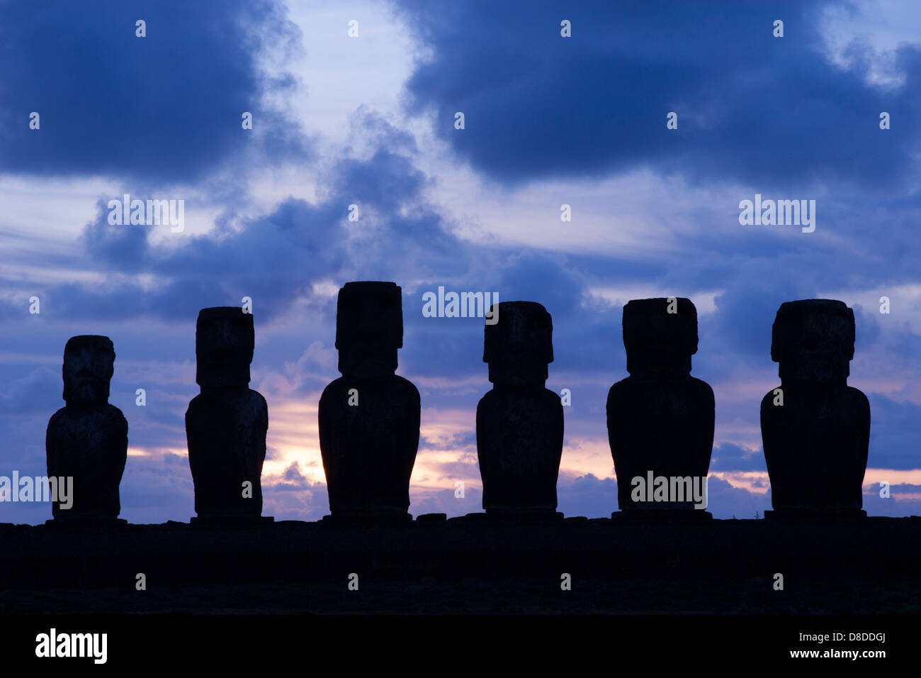 Sechs von Ahu Tongarikis Moai Shilhouetten bei Sonnenaufgang auf der Osterinsel, die in den 1990er Jahren nach dem Sturz während Bürgerkriegen und Tsunami restauriert wurden. Stockfoto