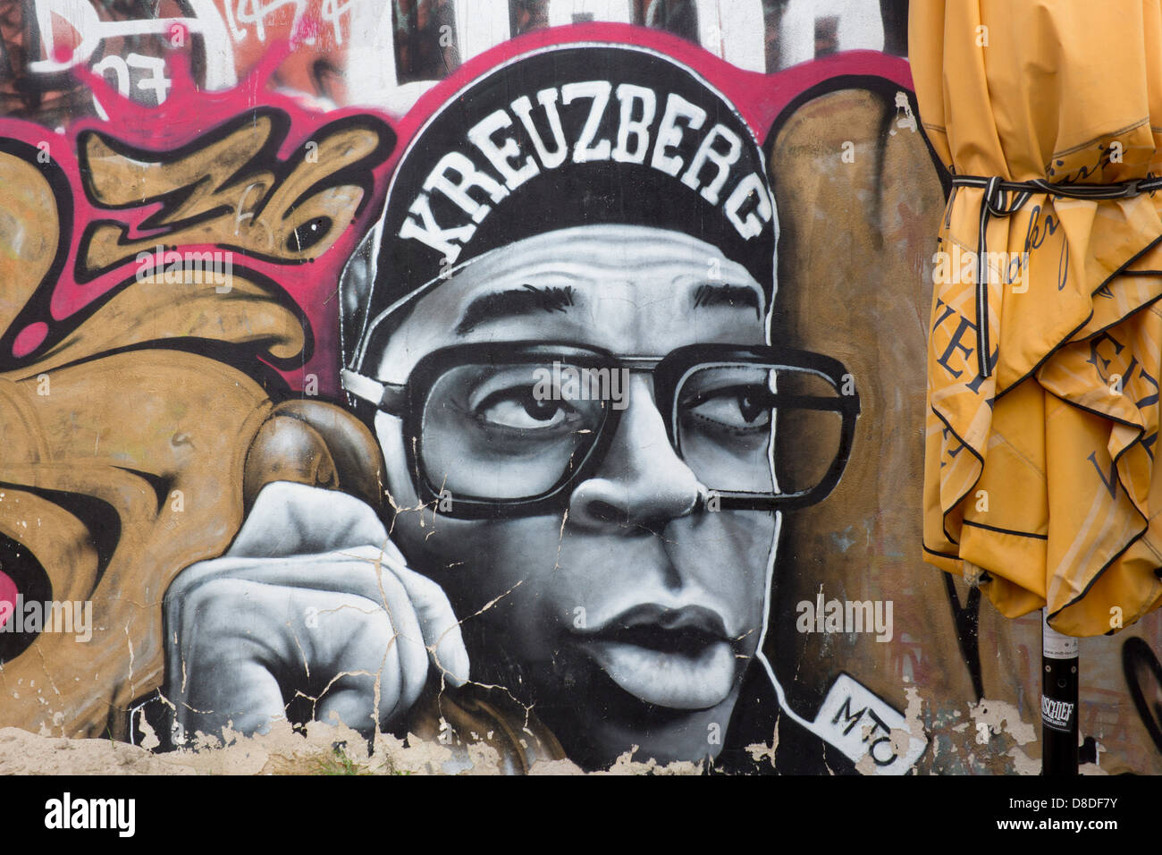 Streetart-Graffiti auf Mauer in Kreuzberg Hip Hop Stil männlichen Charakter spricht am Telefon mit "Kreuzberg" Kappe Berlin Deutschland Stockfoto