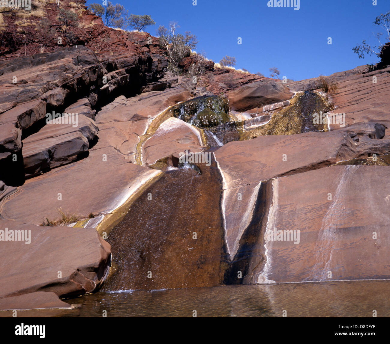 Blick auf die Felswände der Schlucht und kleinen Wasserfall Hamersley Gorge, Karijini-Nationalpark, Pilbara, Australien. Stockfoto