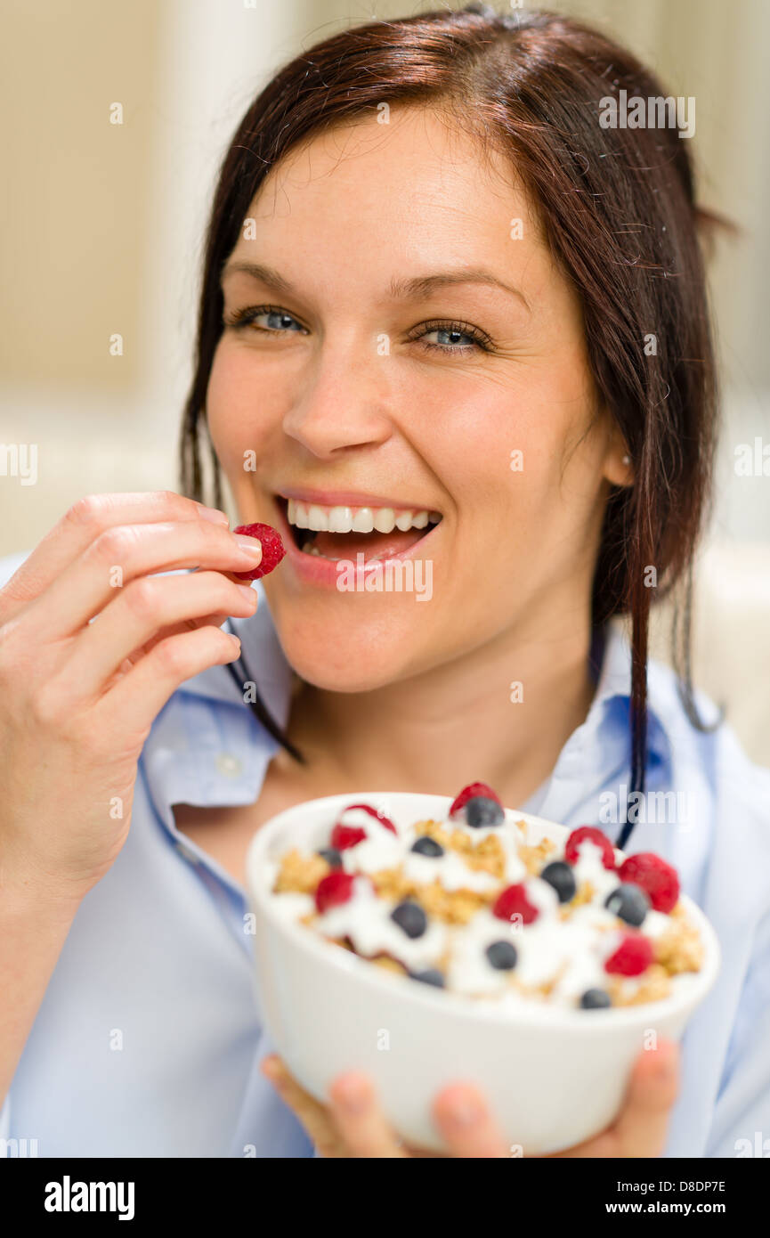 Fröhliche Frau essen gesundes Müsli am Morgen zum Frühstück Stockfoto