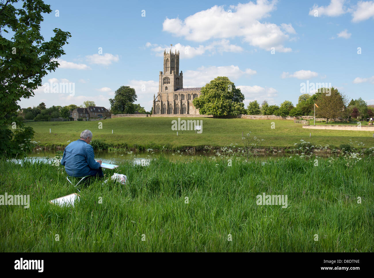 Die Kirche St. Mary und Allerheiligen, Fotheringhay in Northamptonshire mit einem Künstler in den Vordergrund die Szene malen. Stockfoto