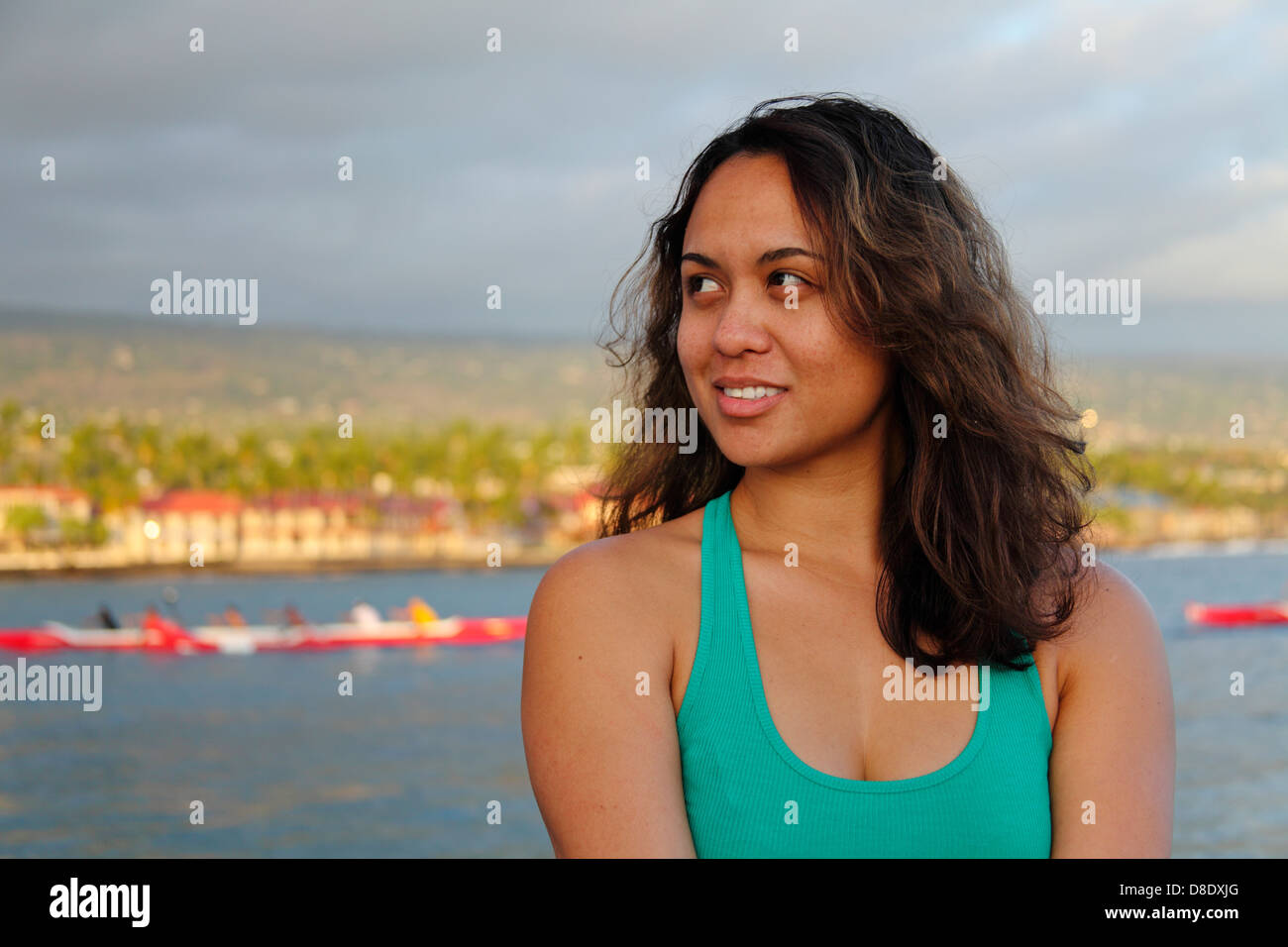 Frau auf dem Pier von Kailua-Kona, mit Ausleger-Kanus im Hintergrund Stockfoto
