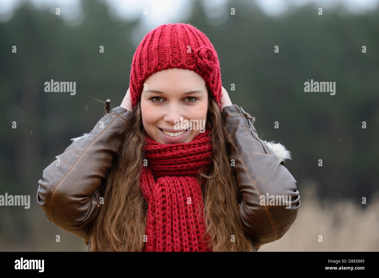 Lächelnde junge Frau mit Mütze und Schal, Porträt Stockfoto