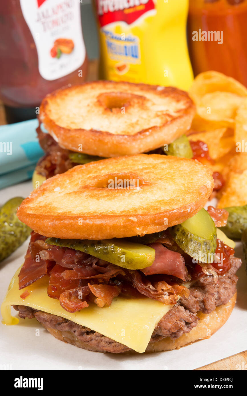 Die Luther-Burger: ein Rindfleisch Patty, Käse, knusprigem Speck und Gurken zwischen beiden Hälften einer verglasten Ring Donut. Stockfoto Die Luther-Burger: ein Rindfleisch Patty, Käse, knusprigem Speck und Gurken zwischen beiden Hälften einer verglasten Ring Donut. Stockfoto