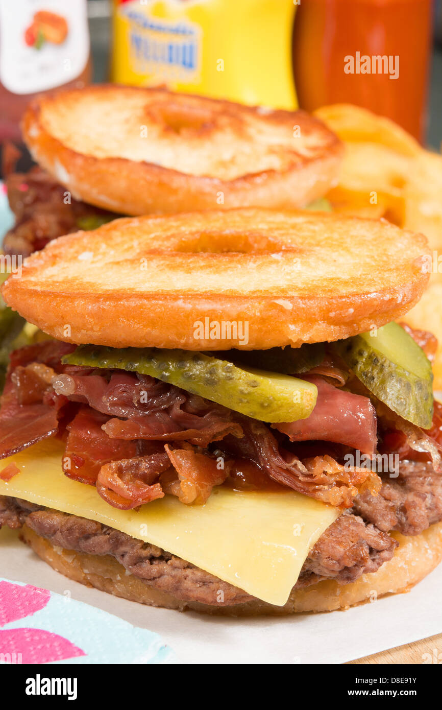 Die Luther-Burger: ein Rindfleisch Patty, Käse, knusprigem Speck und Gurken zwischen beiden Hälften einer verglasten Ring Donut. Stockfoto Die Luther-Burger: ein Rindfleisch Patty, Käse, knusprigem Speck und Gurken zwischen beiden Hälften einer verglasten Ring Donut. Stockfoto