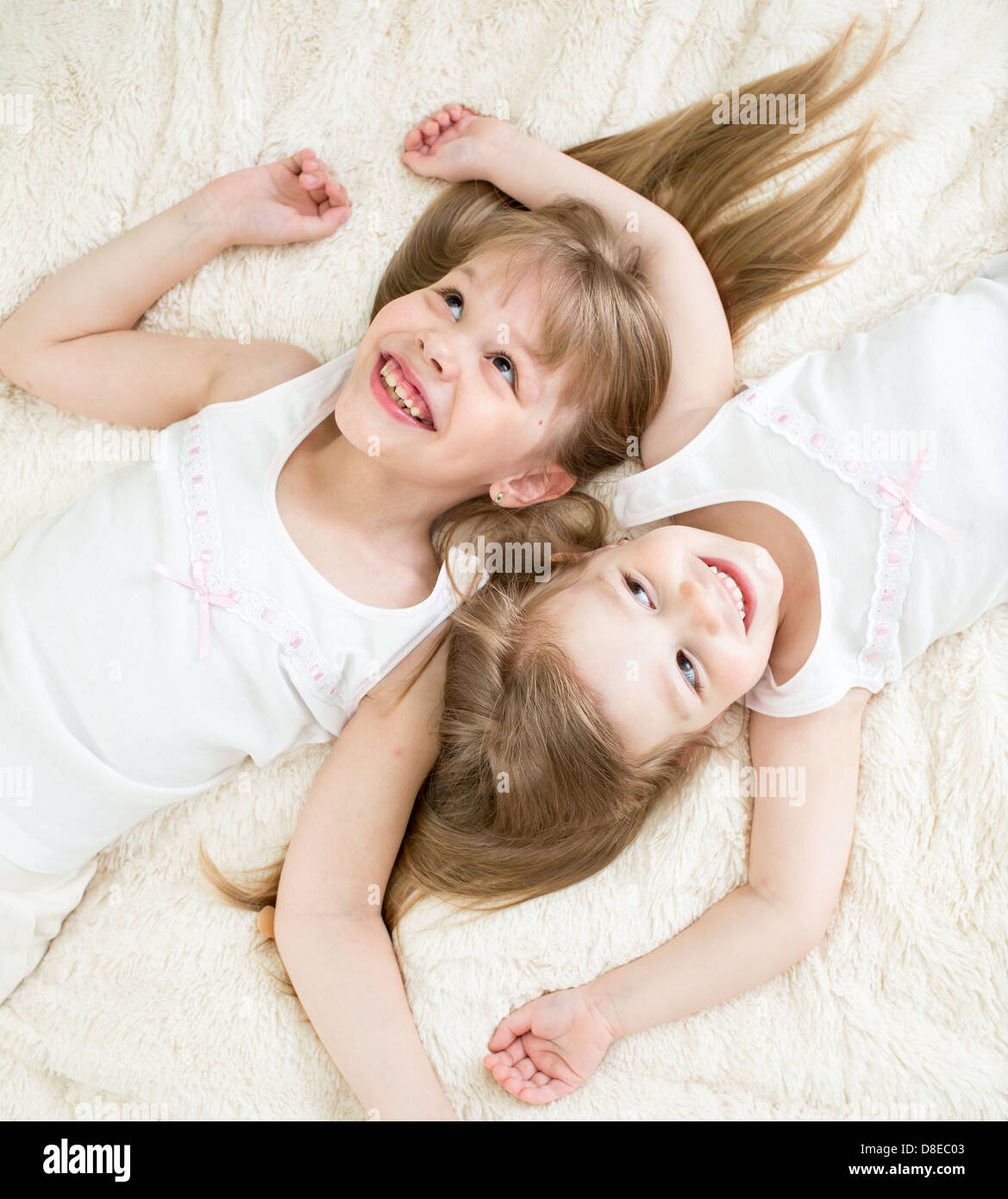 glückliche Kinder auf Rücken in Pyjamas Draufsicht Stockfoto