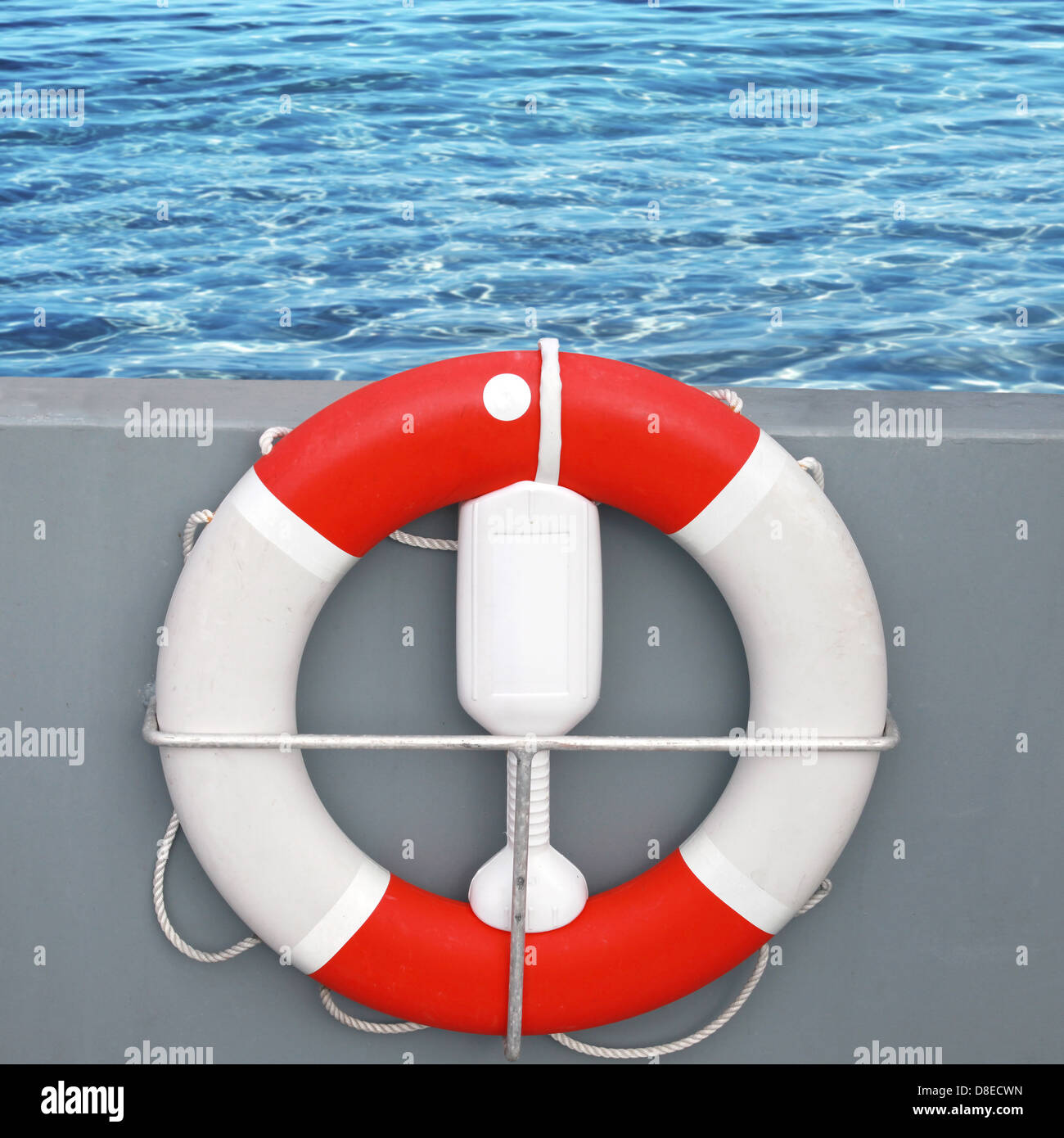 Rote und weiße Rettungsring mit Seil mit Meerwasser auf einem Hintergrund Stockfoto