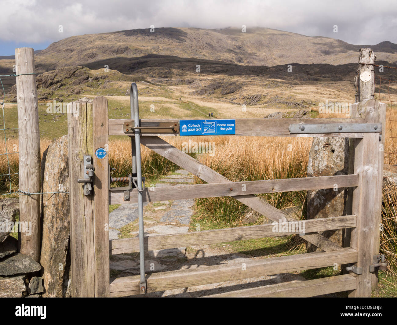 Gate mit Rasterreferenzscheibe auf dem Rhyd Ddu-Pfad hinauf zum Mt Snowdon mit Blick auf den fernen Gipfel im Snowdonia National Park (Eryri), Nordwales, Großbritannien Stockfoto