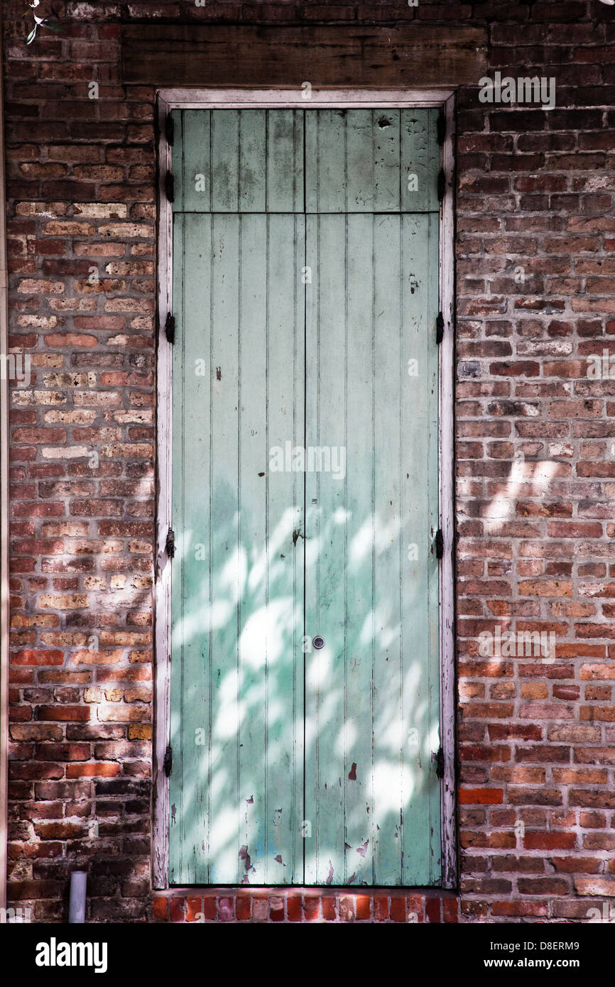 Türkise Tür in eine Mauer, gefleckten Schatten Stockfoto