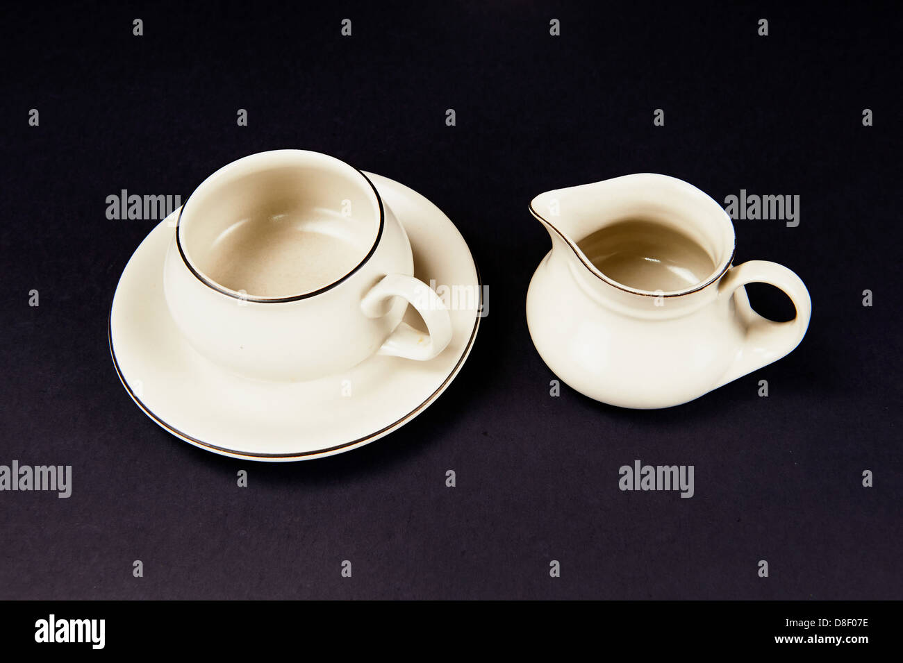Teetasse auf einen Teller und Milch Krug Stockfoto