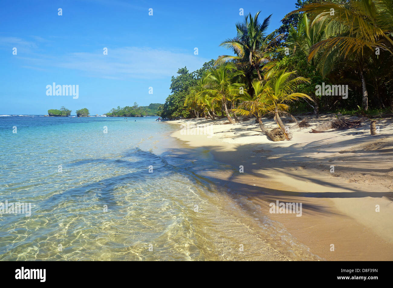 Unberührten Strand mit Schatten der Kokospalmen auf den Sand und die Inseln im Hintergrund Stockfoto