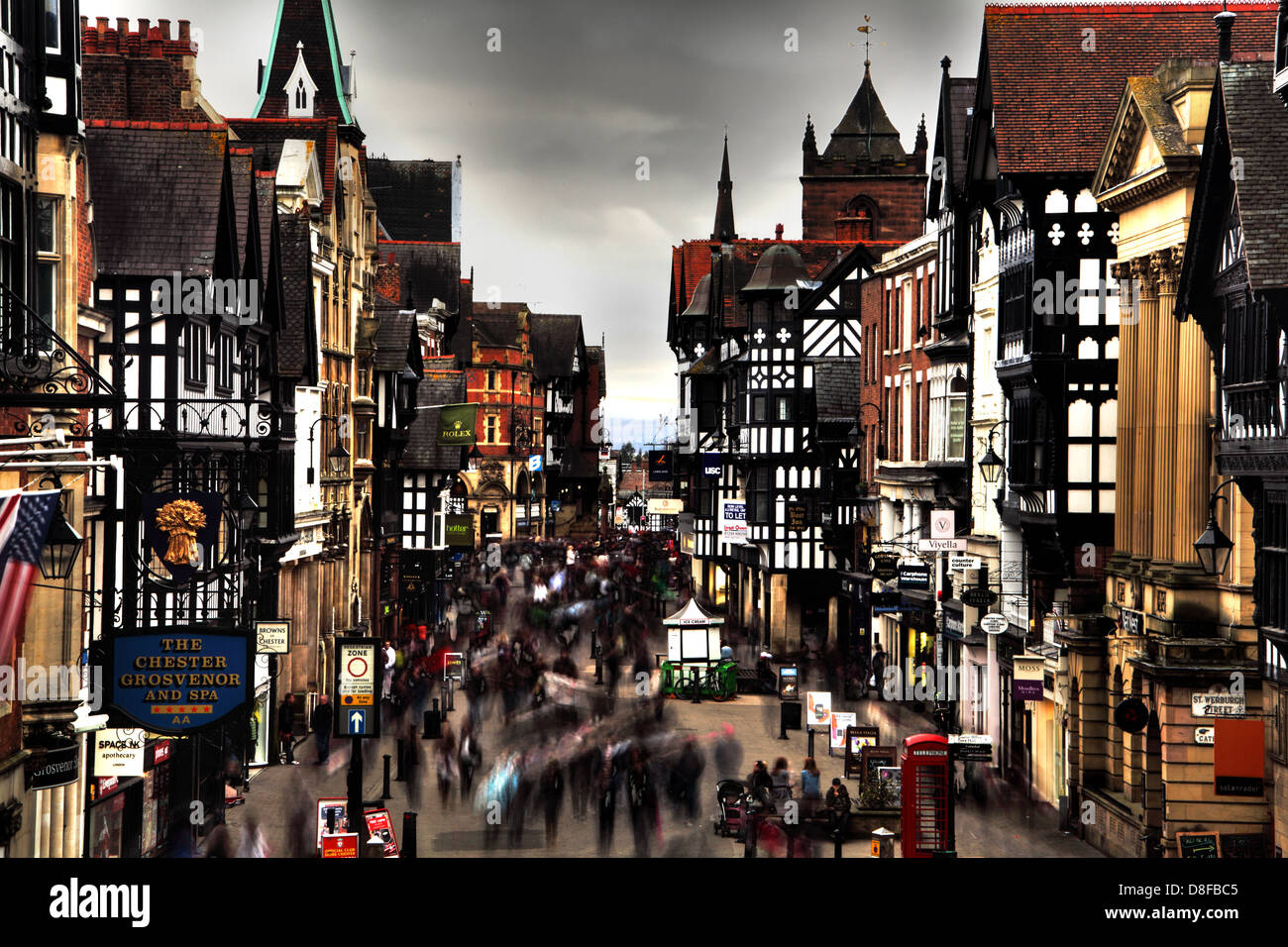 Geschäftige Shopper Chester Eastgate beschäftigt nass Samstag, in der Fußgängerzone. Cheshire, England UK Stockfoto