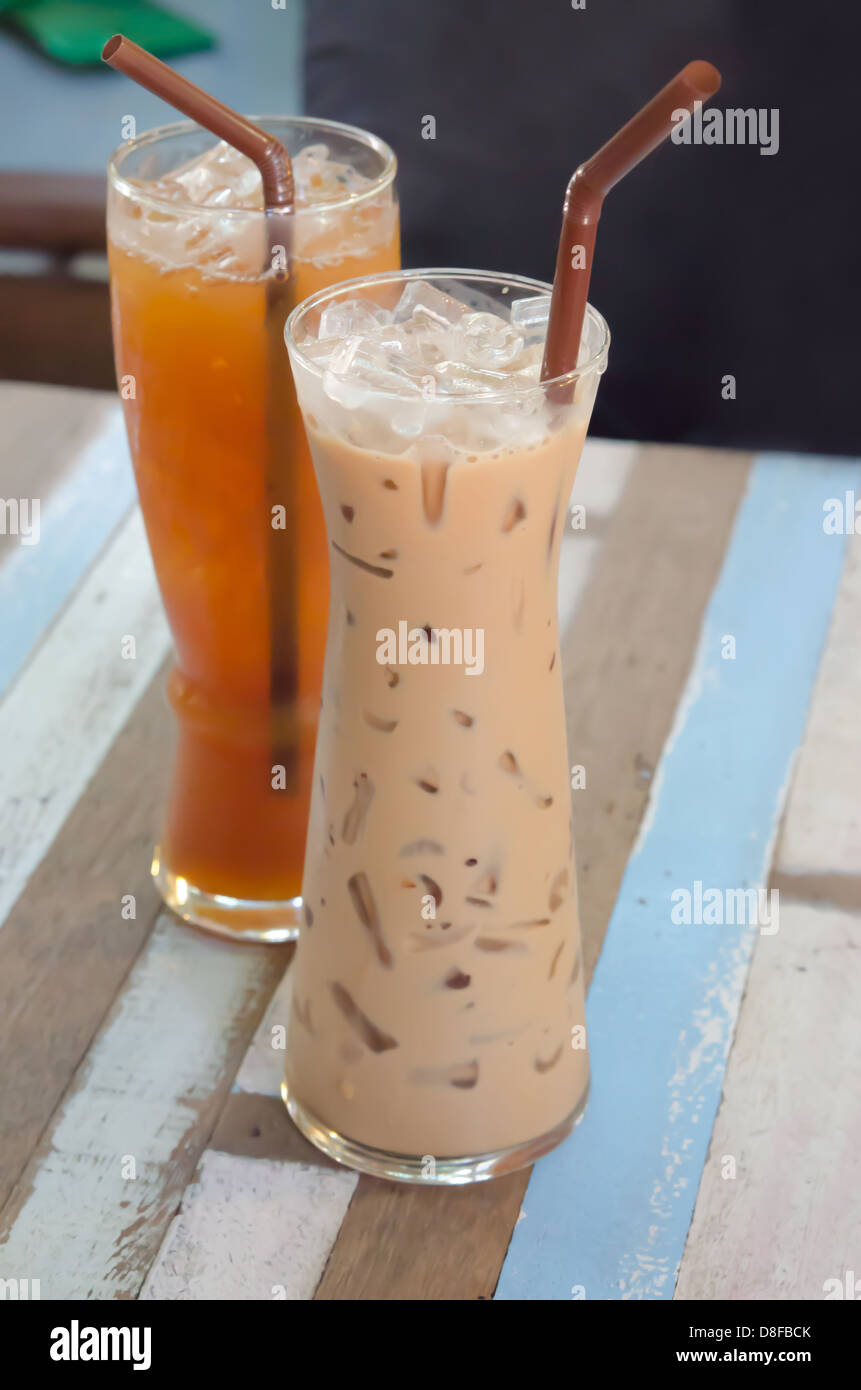 Eiskaffee und Eistee mit Stroh auf Tisch trinken Stockfoto