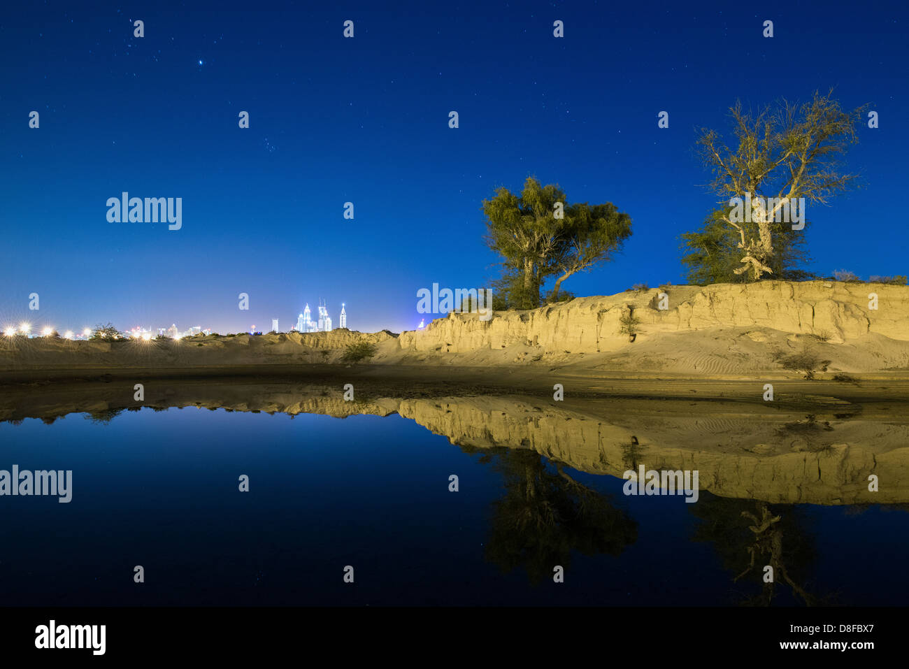 Skyline von New Dubai spiegelt sich in einem Regenwasser-See in der Wüste, Vereinigte Arabische Emirate Stockfoto