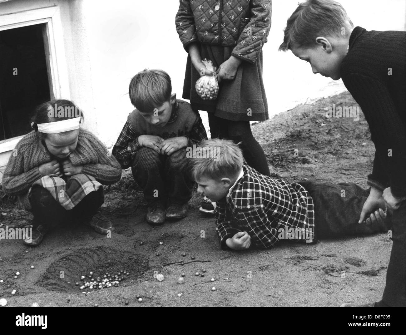 Eine Gruppe von Kindern spielt Murmeln am 11. Mai 1965. Stockfoto