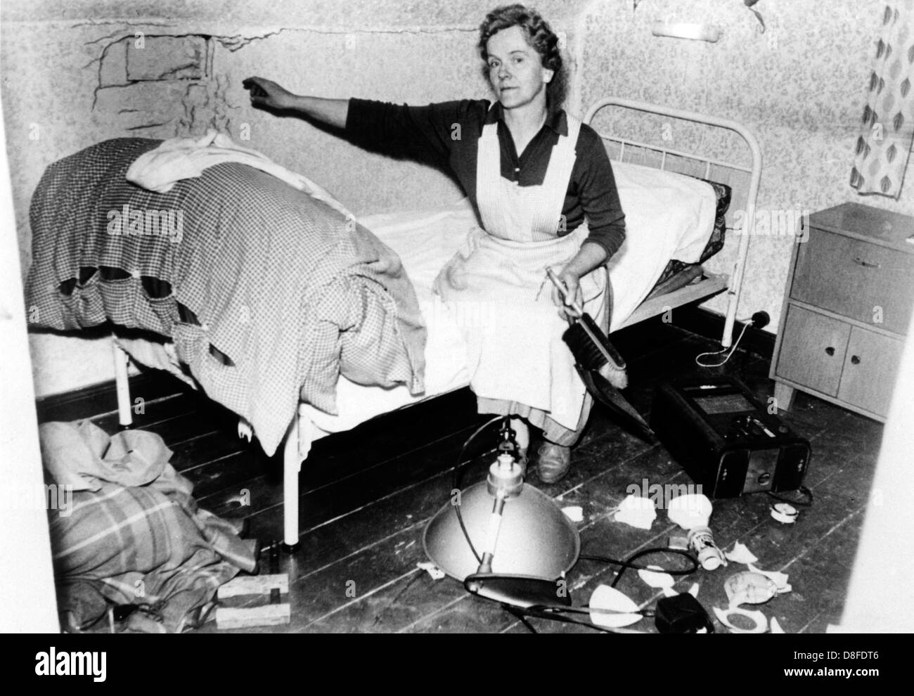 Die Ehefrau von der Dorfpolizist in einem abgerissenen Raum ihres Hauses in Niedersachsen am 27. April 1961. Das Haus wurde von einem Tank der britischen Armee beschädigt, während es Munition, während einer Übung 20 Meter entfernt geschossen wurde. Stockfoto