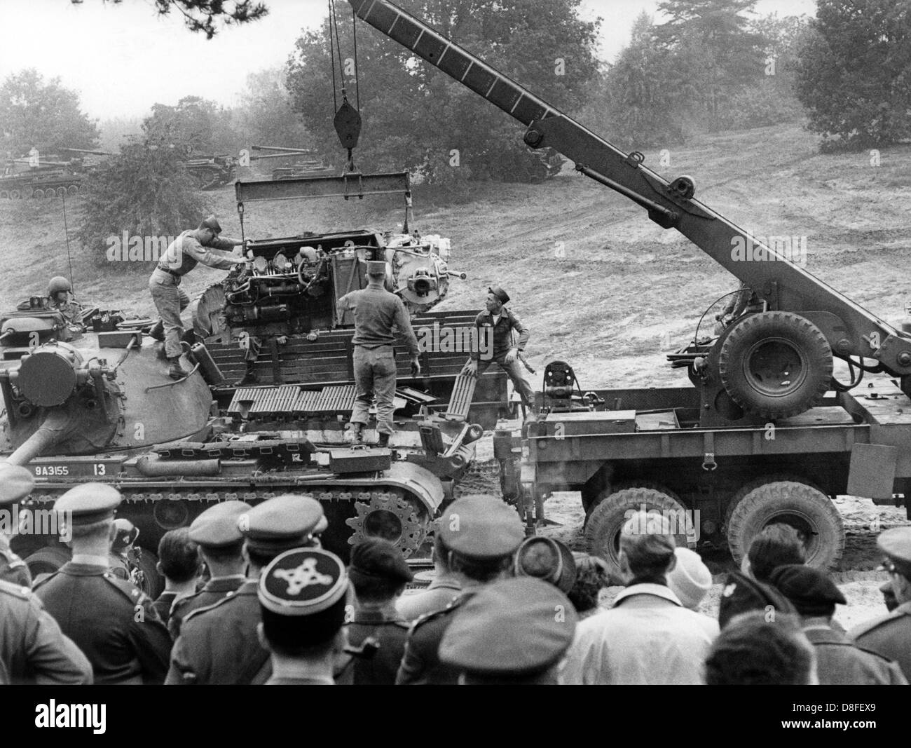Amerikanische Mechanik ändern den Motor eines Patton-Panzers unter den Augen der westlichen Alliierten Offiziere im Rahmen der alliierten Panzer zu Übungszwecken im Grunewald in Berlin am 11. Oktober 1962. Die Übung war Bestandteil einer alliierten Panzer Manöver, in denen Truppen und Fahrzeuge der amerikanischen, französischen und britischen Streitkräfte beteiligt. Stockfoto