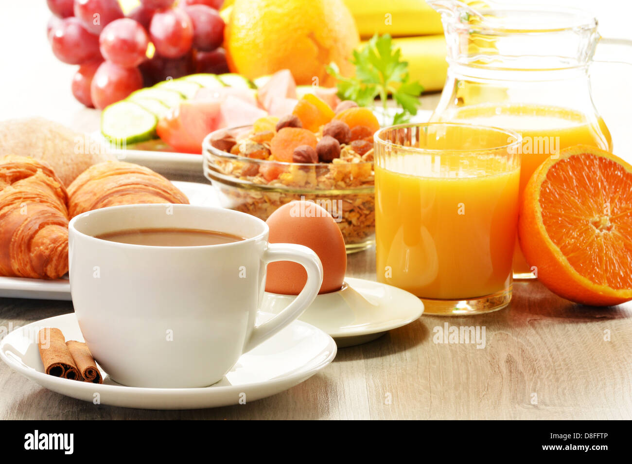 Frühstück mit Kaffee, Orangensaft, Croissant, Ei, Gemüse und Obst Stockfoto