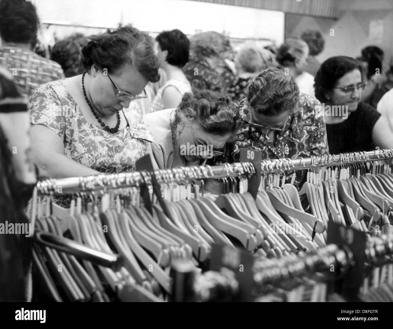 Frauen in der Abteilung für Damenbekleidung in einem Kaufhaus in Frankfurt sind auf der Suche nach spezieller angeboten. Bild vom Juli 1962. Stockfoto