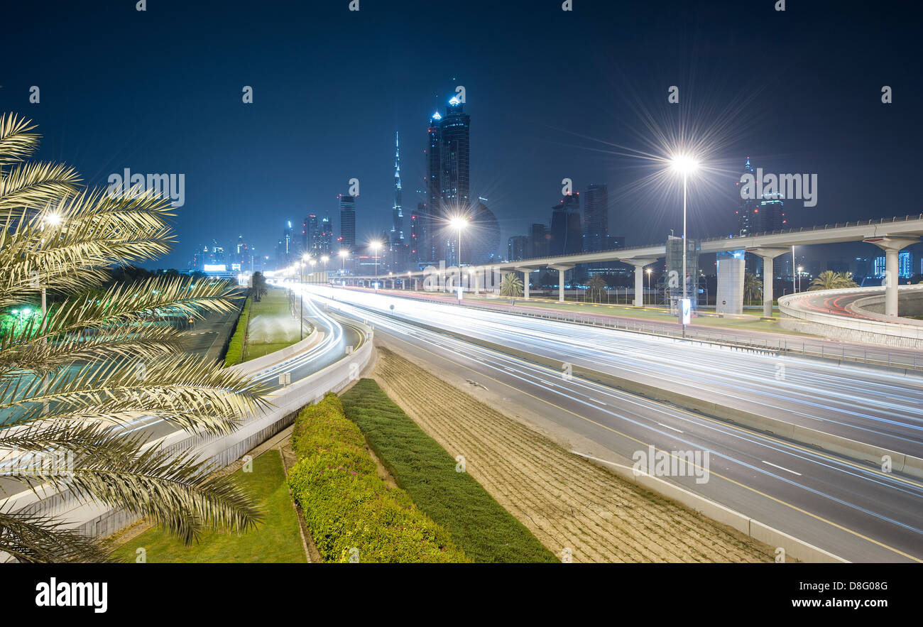 Die Innenstadt von Dubai Skyline Nacht von einer Autobahnausfahrt auf der Sheikh Zayed Road Safa Park Gärten Handfläche Bäume Dubai Vereinigte Arabische Emirate Stockfoto