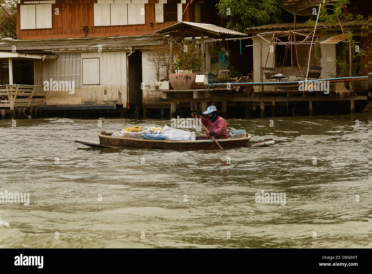 Ein Händler auf dem Chao Phraya in Bangkok nimmt frische Bananen und andere Früchte, Touristen und andere mit dem Fluss zu reizen. Stockfoto