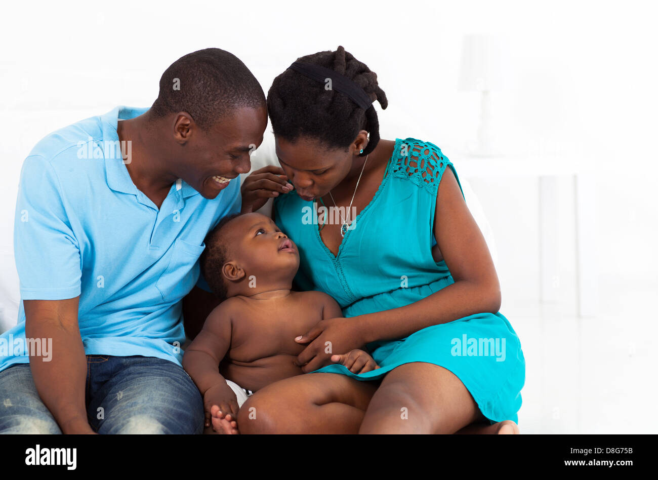 glückliche afroamerikanischen Eltern spielen mit Baby im Schlafzimmer Stockfoto