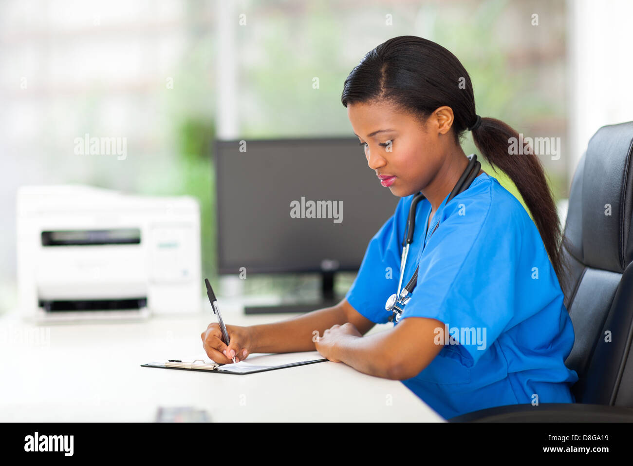 schöne afrikanische Kinderkrankenschwester medizinischen Berichte schreiben Stockfoto