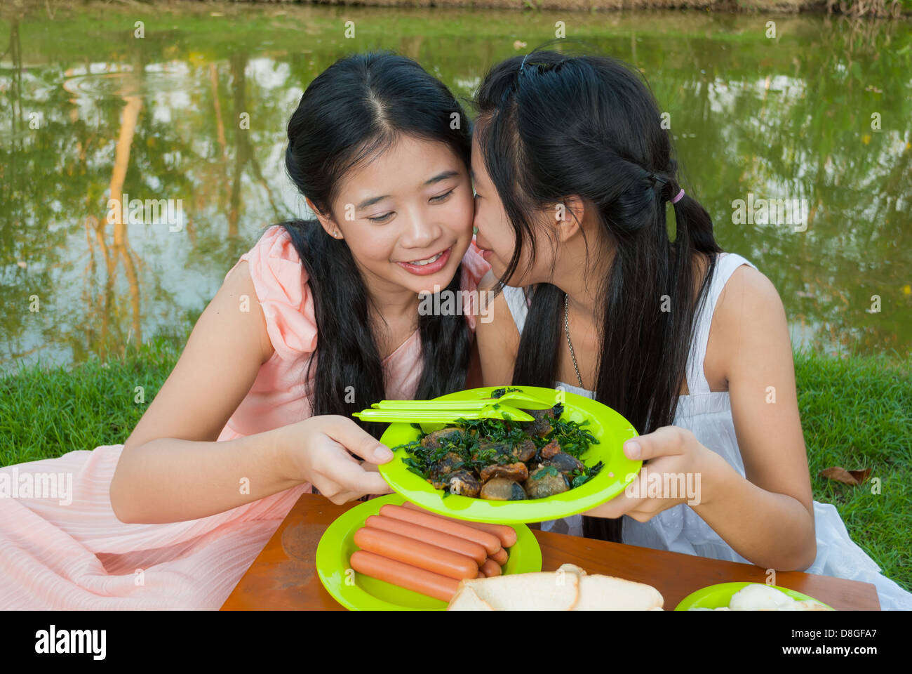 Asiatische Thai Schwester Picknick zusammen neben Sumpf. Stockfoto