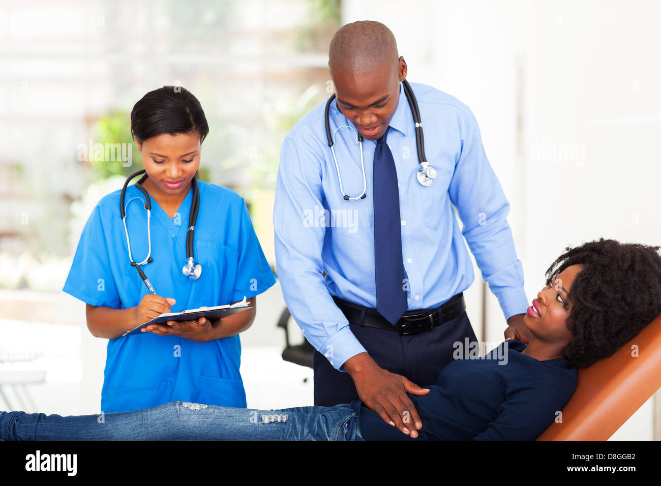 Afrikanischen Arzt und Krankenschwester Untersuchung Patientin im Büro Stockfoto