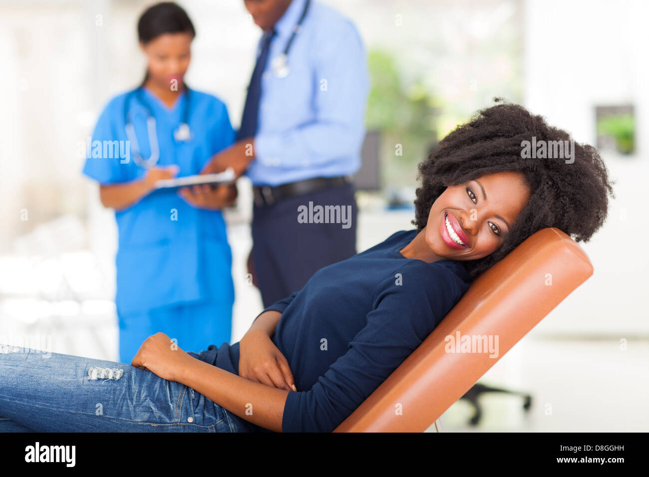 glücklich Afrikanerin liegen auf ärztliche Prüfung Bett und wartet auf medizinischer checkup Stockfoto