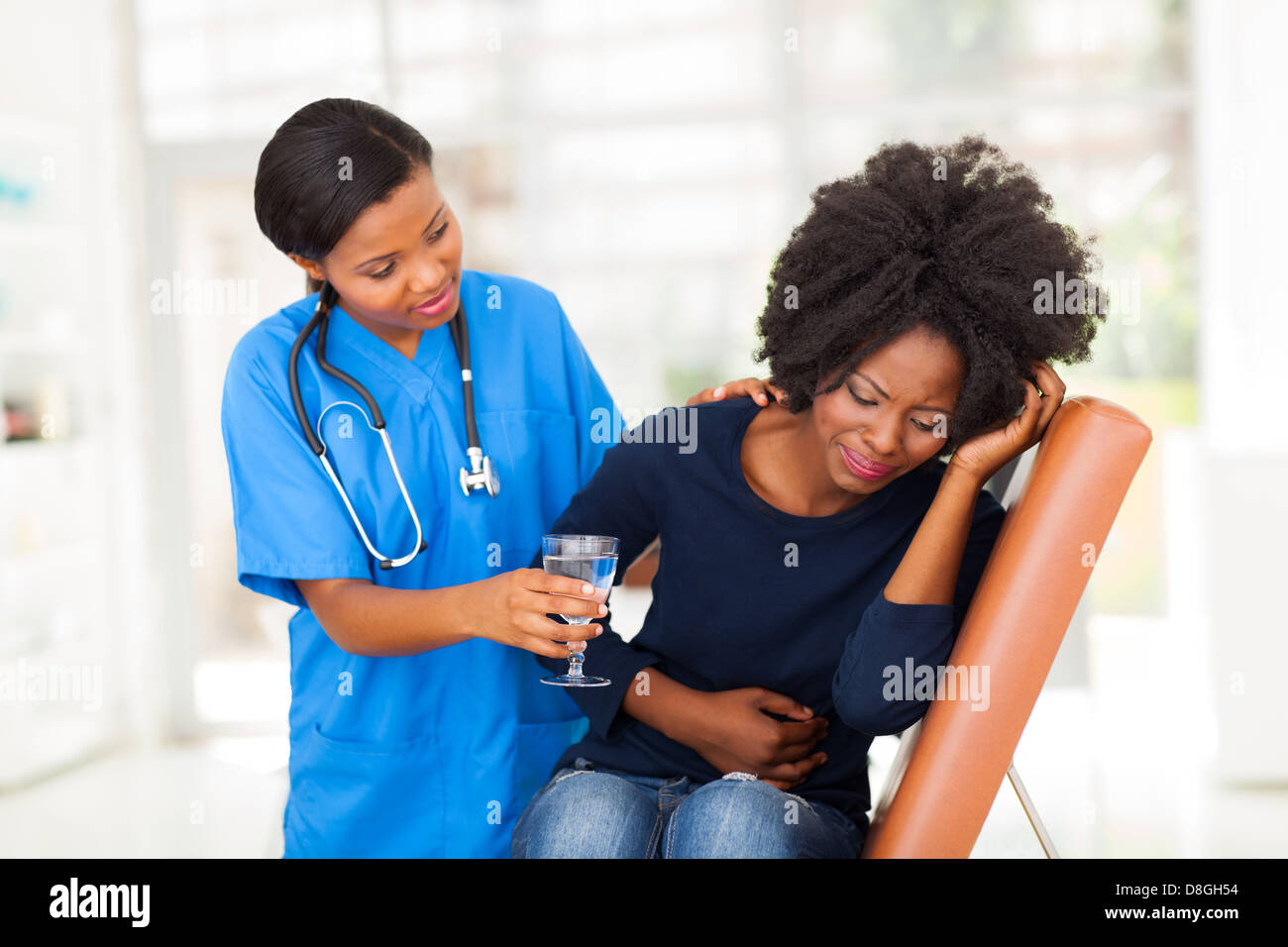 junge afrikanische amerikanische Krankenschwester kranke Patienten Wasser Pflege Stockfoto