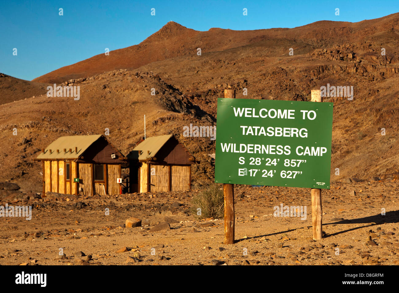 Willkommensschild mit GPS-Standortinformationen am Eingang zum Tatasberg Wilderness Camp, Richtersveld, Südafrika Stockfoto